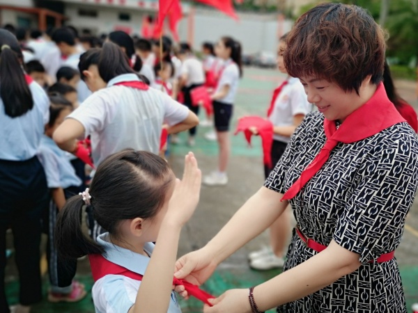 鄒麗校長給新隊員佩戴紅領(lǐng)巾